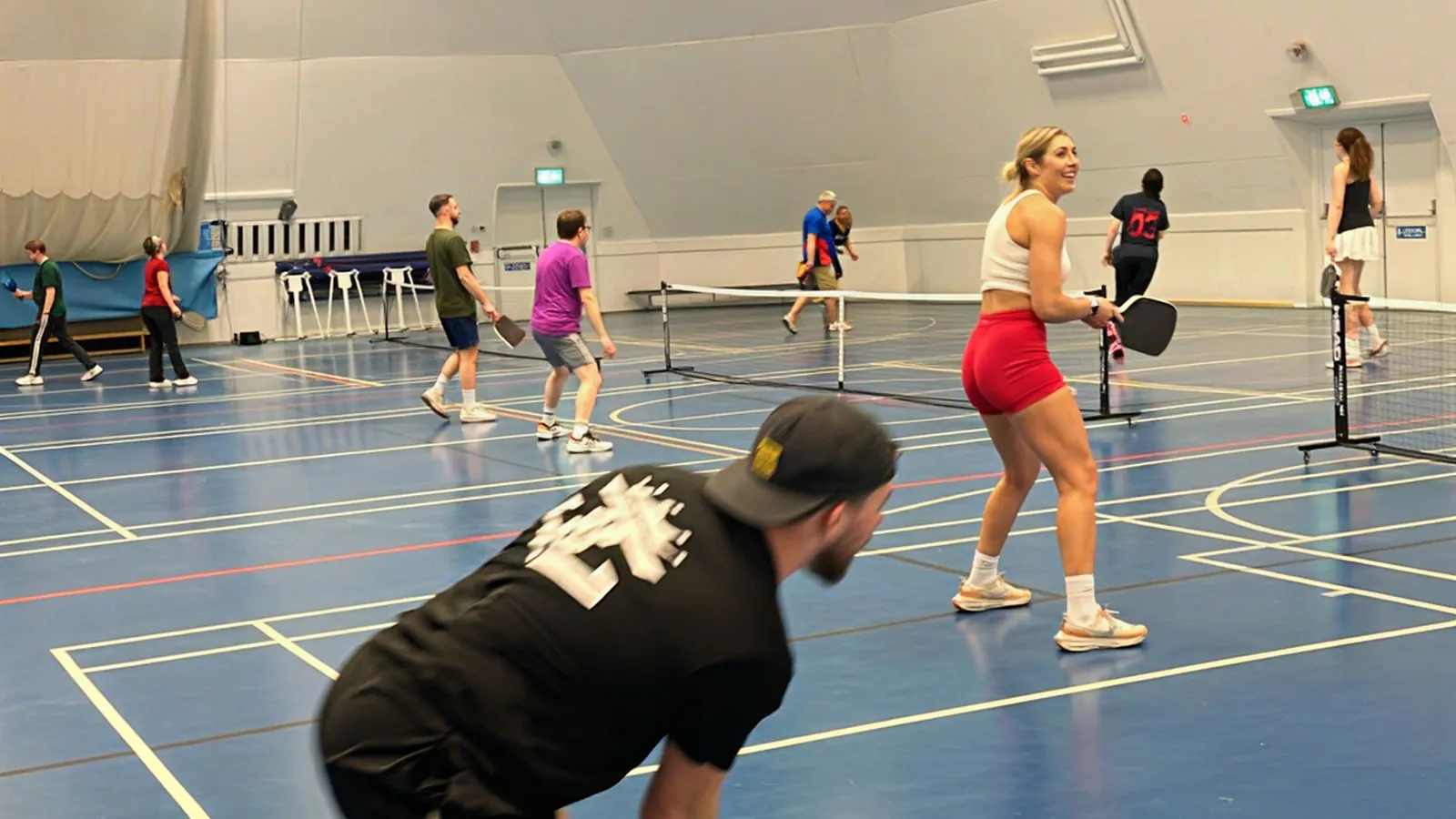 Players at the net during an indoor pickleball session